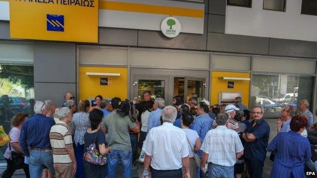 Greek pensioners queue to withdraw money from a bank in Athens