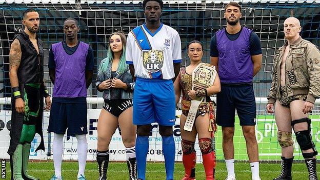 NXT UK wrestlers Eddie Dennis, Dani Luna, women's champion Meiko Satomura and Sam Gradwell help launch Enfield Town's new kit, along with defender Jeremiah Gyebi