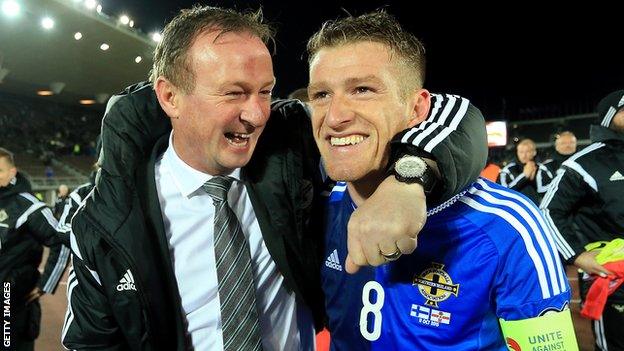 Michael O'Neill celebrates with Steven Davies