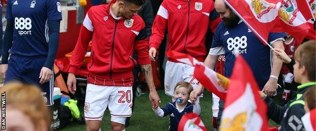 Bristol City's Jamie Paterson leads Nottingham Forest fan Tyler Cove out onto the pitch at Ashton Gate