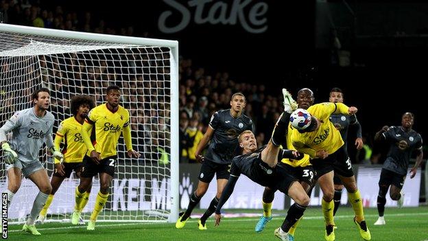 Francisco Sierralta of Watford heads the ball away from the attempted shot by Jay Fulton of Swansea City