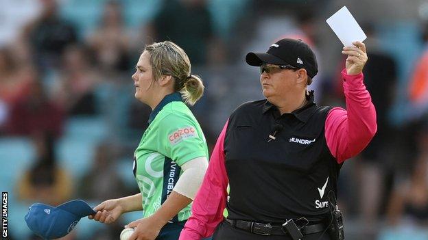 Umpire raises a white card