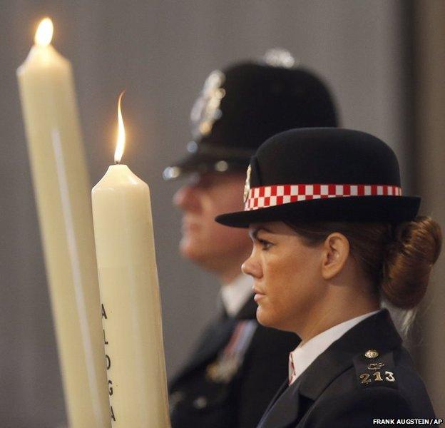 Police officers carry candles bearing the names of the bombed places