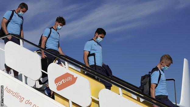 Manchester City's players get off a plane in Portugal on Monday