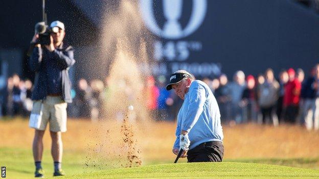 Colin Montgomerie hits the ball out the bunker on the first hole