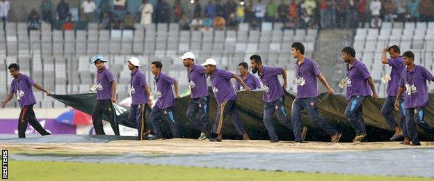 Ground staff bring the covers on