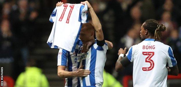 Steve Sidwell holds up Anthony Knockaert's shirt