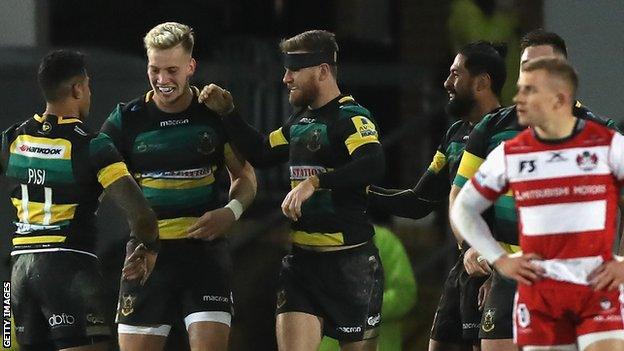 Northampton Saints players celebrate scoring a try against Gloucester