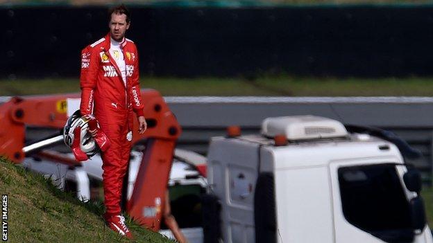 Sebastian Vettel stands alone after colliding with team-mate Charles Leclerc