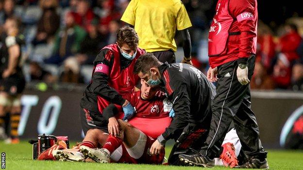 Joey Carbery receives medical attention with his arm in a makeshift sling