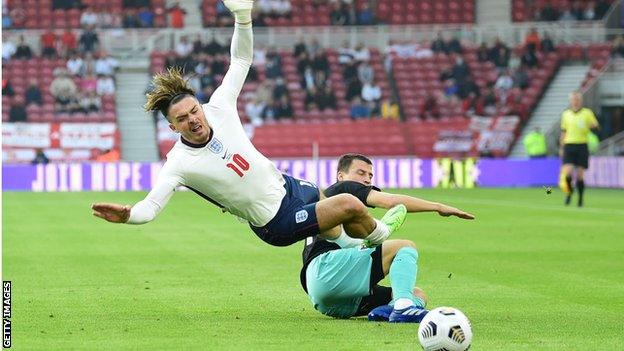 Jack Grealish goes down after a challenge against Austria