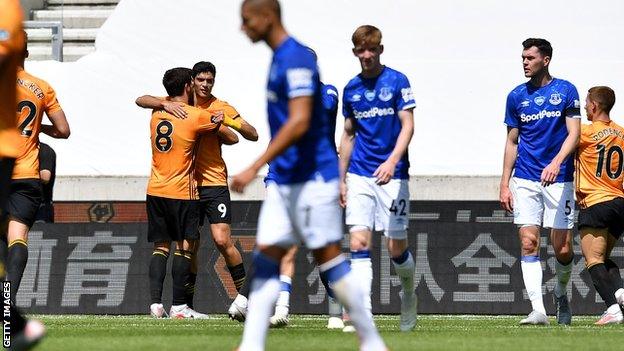 Raul Jimenez celebrates with Ruben Neves (number 8) as Everton players look despondent