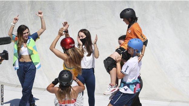 Misugu Okamoto is lifted in the air by her fellow competitors after falling in the women's park final