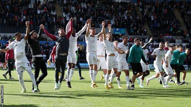 Swansea players and staff celebrate after making south Wales derby history