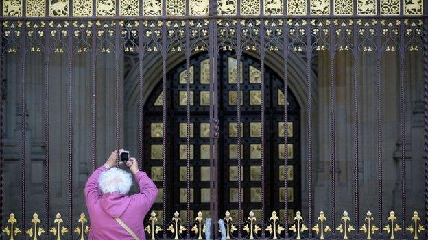 Tourist taking picture of entrance to the Palace of Westminster