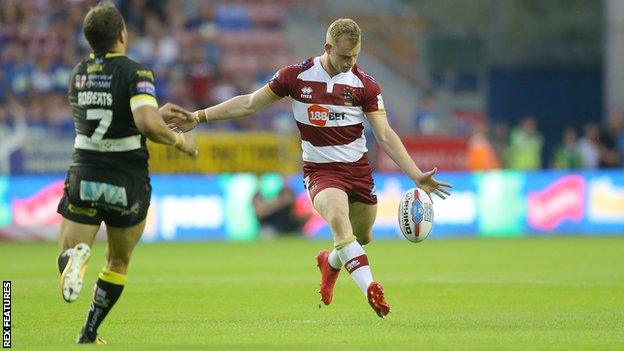 Wigan Warriors player Josh Woods kicks his match-winning drop-goal