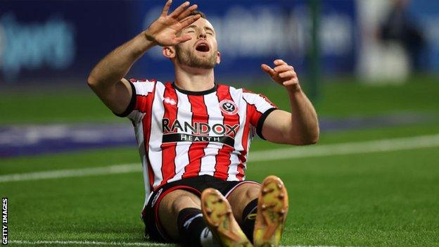 Rhys Norrington-Davies of Sheffield United lies injured before being taken off on a stretcher