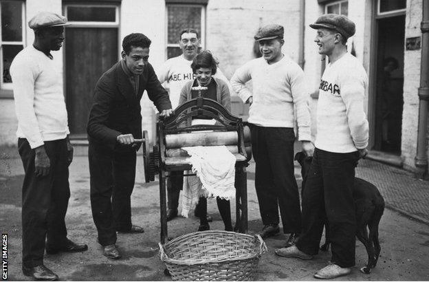 31st December 1926: Len Johnson British light-heavyweight boxing champion, helps with the mangling, his father is on the left. (Photo by Brooke/Topical Press Agency/Getty Images)