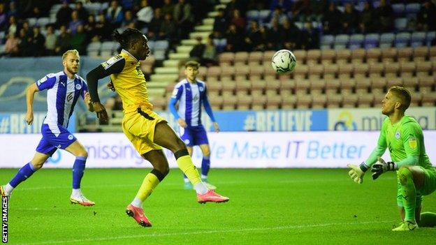 Dan N'Lundulu opens the scoring for Lincoln at Wigan