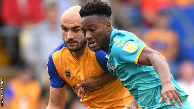 Timmy Abraham of Newport County is tackled by Mansfield's Farrend Rawson