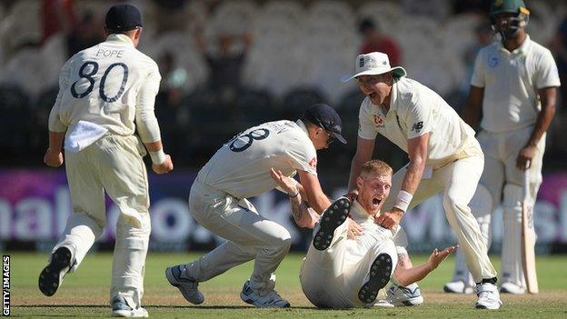 England's Ben Stokes falls to the ground and is mobbed by team-mates after taking a wicket on day five of the second Test against South Africa