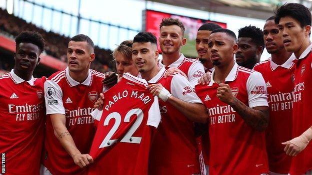 Arsenal players hold up a shirt with Pablo Mari's name on after Gabriel Martinelli scored against Nottingham Forest