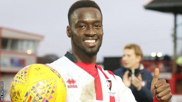 Mohamed Eisa poses with the match ball after scoring a hat-trick for Cheltenham