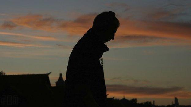 Silhouette of man walking with headphones