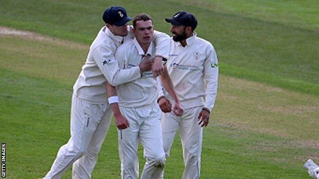 Sam Conners (centre) is congratulated by team-mates after taking the wicket of Harry Swindells