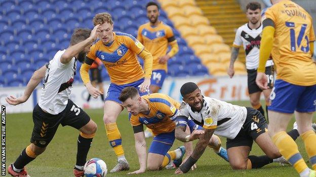 Joss Labadie of Newport County and Ollie Clarke of Mansfield Town scramble for the ball