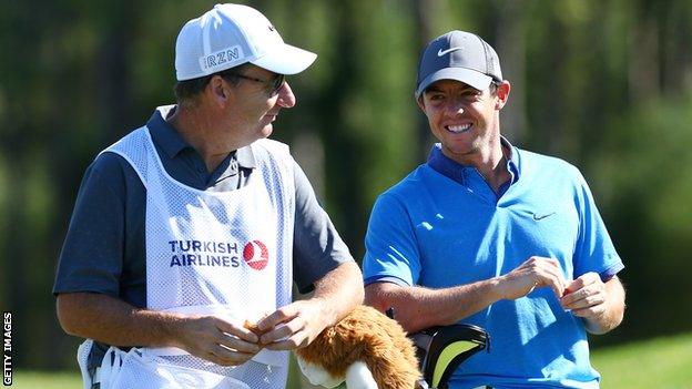 Rory McIlroy consults with his caddie during a practice round ahead of the Turkish Airlines Open