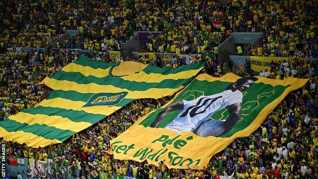 A large Pele flag saying Get Well Soon in the World Cup crowd