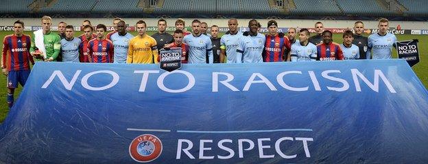 Players pose behind an anti-racism banner in the empty Khimki Arena before the UEFA Champions League group E football match between CSKA Moscow and Manchester City in Moscow on 21 October, 2014