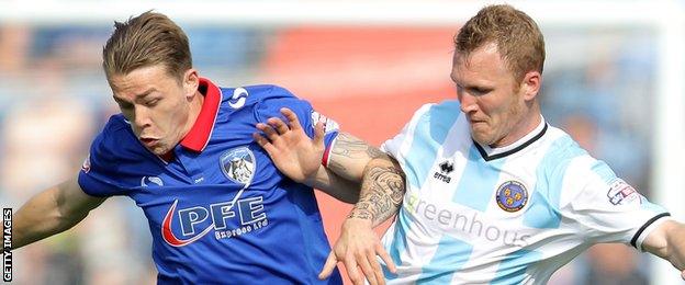 George Green holds off Shrewsbury Town's Mark Ellis with Oldham Athletic