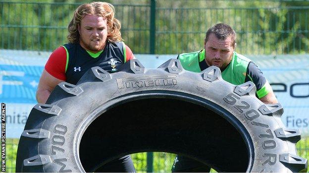 Kristian Dacey and Ken Owens grapple with a huge tyre during Wales training in Switzerland