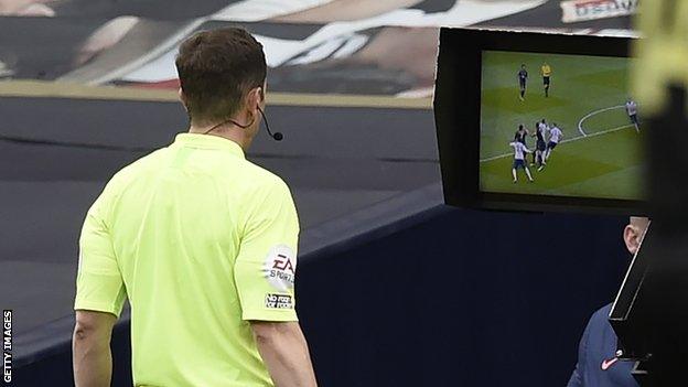 Referee Peter Bankes looks at the monitor