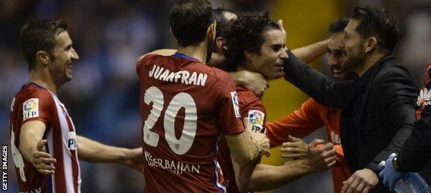 The Atletico players celebrate with their manager