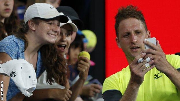 Tennys Sandgren poses for selfies after his victory