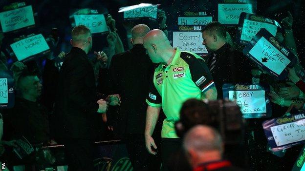 Michael van Gerwen turns to face the crowd after he was soaked in beer at Alexandra Palace