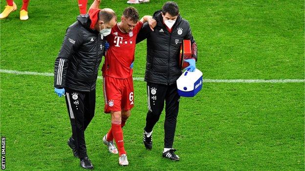 Bayern Munich midfielder Joshua Kimmich is helped from the field after injuring his knee against Borussia Dortmund