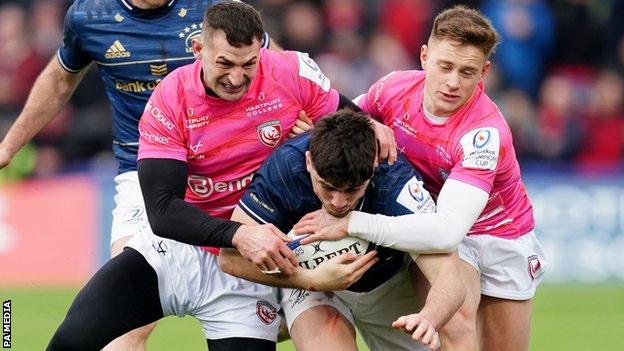 Gloucester players tackle an opponent from Leinster