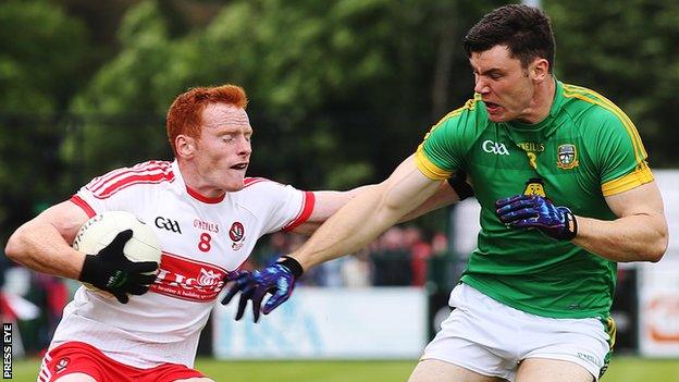 Derry's Conor McAtamney is challenged by Harry Rooney of Meath