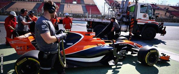 A member of the McLaren team inspects the car of Stoffel Vandoorne of Belgium and McLaren Honda after it stopped on track during day three of Formula One winter testing