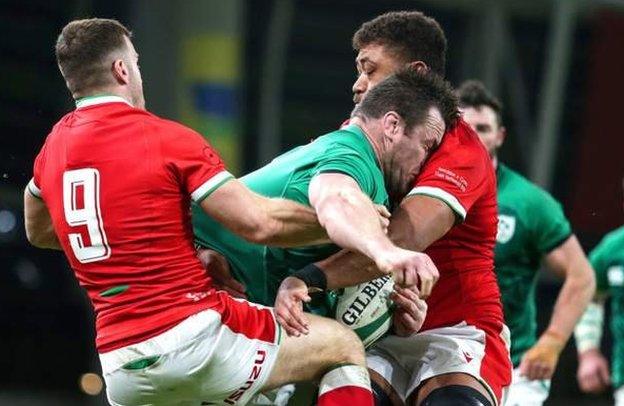 Cian Healy yn cael ei daclo gan Taulupe Faletau a Gareth Davies