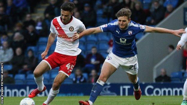Aaron Collins of Newport County holds off the challenge from Laurence Maguire