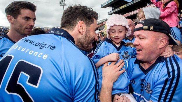 Dublin stars Michael Darragh Macauley and Bernard Brogan greet a young fan after the Leinster Final earlier this month