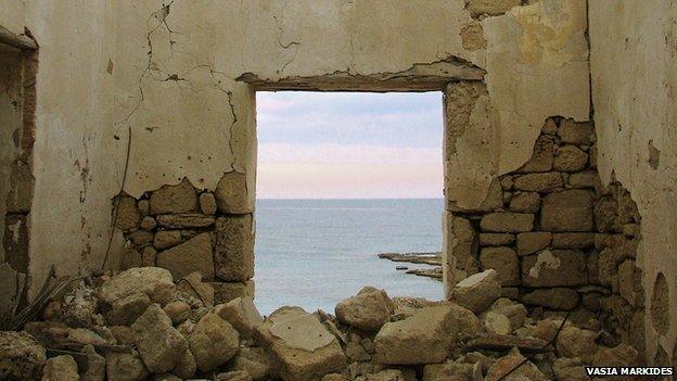 a view of the sea through a broken doorframe