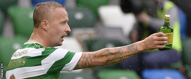 Celtic's Leigh Griffiths handed the referee a bottle which had been thrown on to the pitch