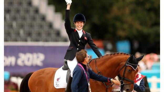 Sophie Christiansen waves on her horse