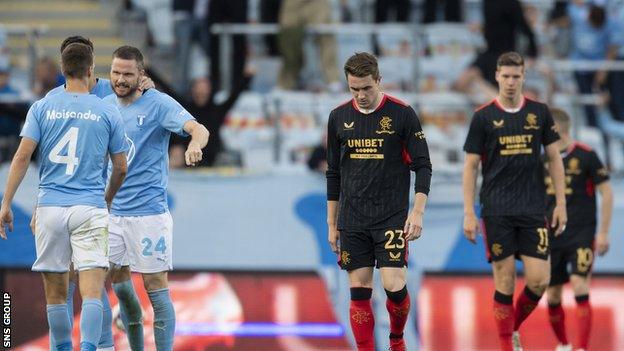 Malmo celebrate increasing their lead as Rangers' Scott Wright and Cedric Itten trudge back to halway